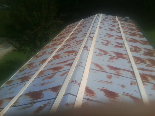 Rusted metal roof panels with new wood purlins before replacement — Storm Damage Roof Repair in Westville by Roofing Brothers