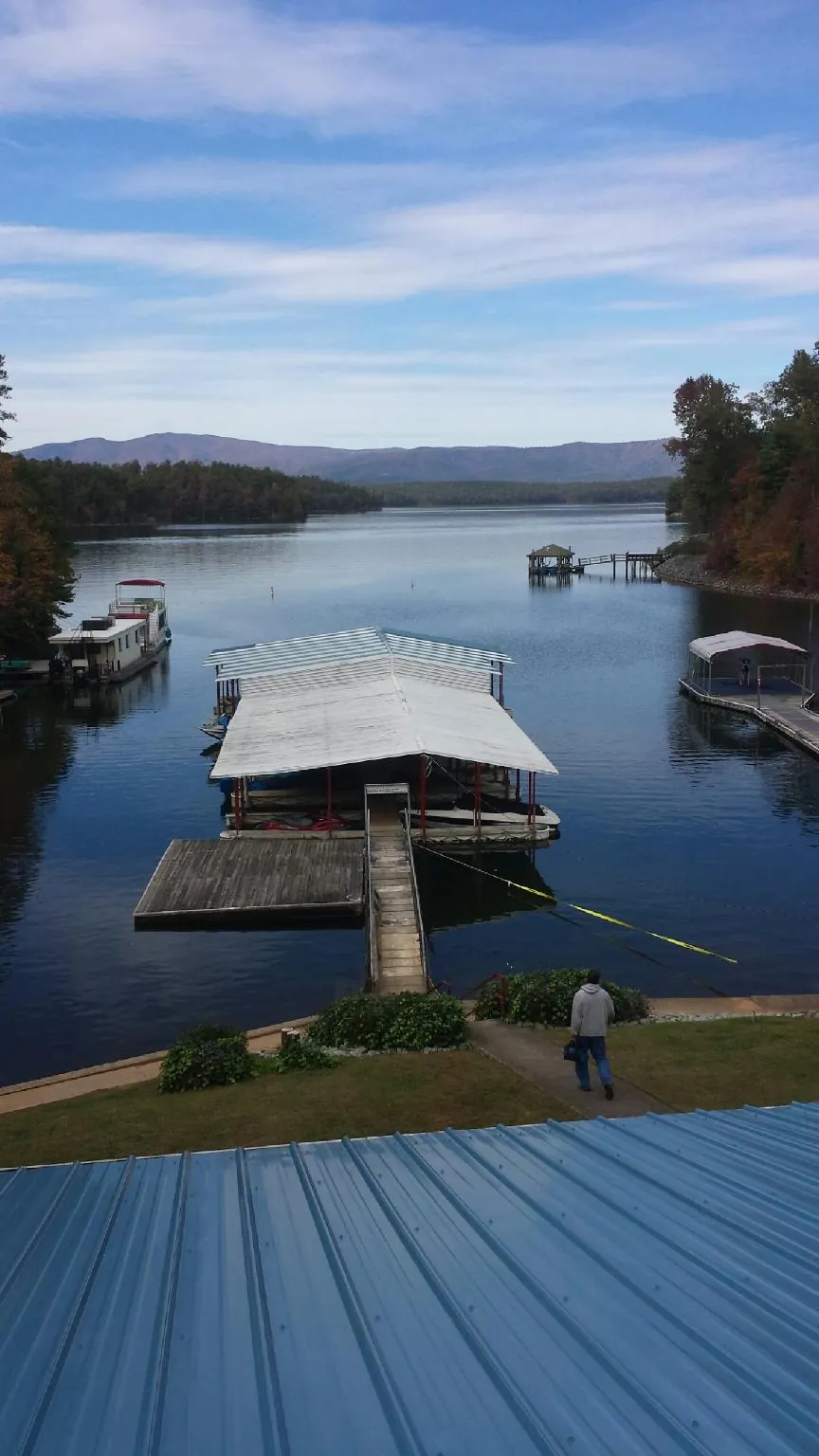 View across a lake from a newly installed blue metal roof in Westville