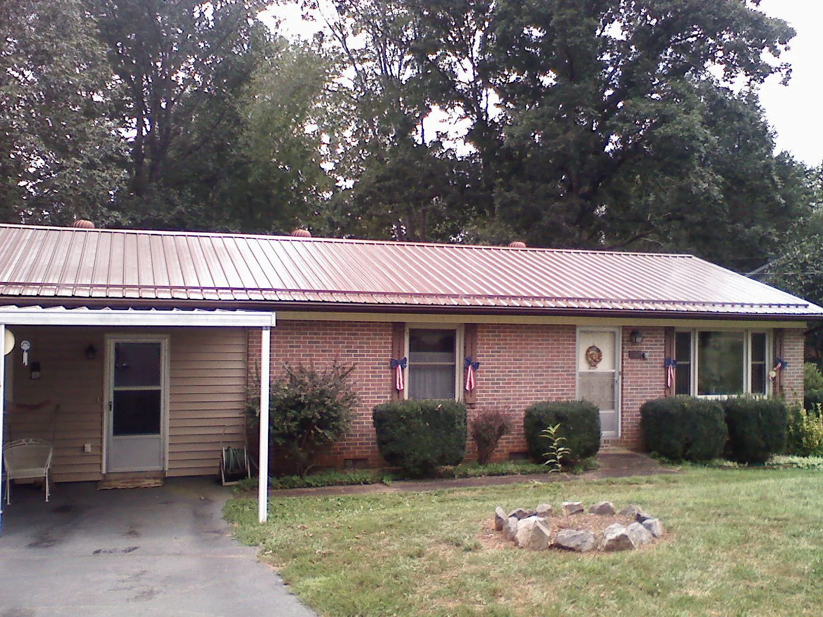Bronze metal roof and carport on a brick ranch home — Roof Repair work by our crew in Westville